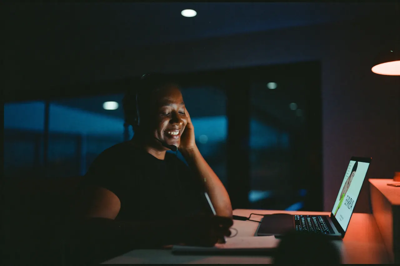 A patient coordinator wearing a headset, smiling during a call